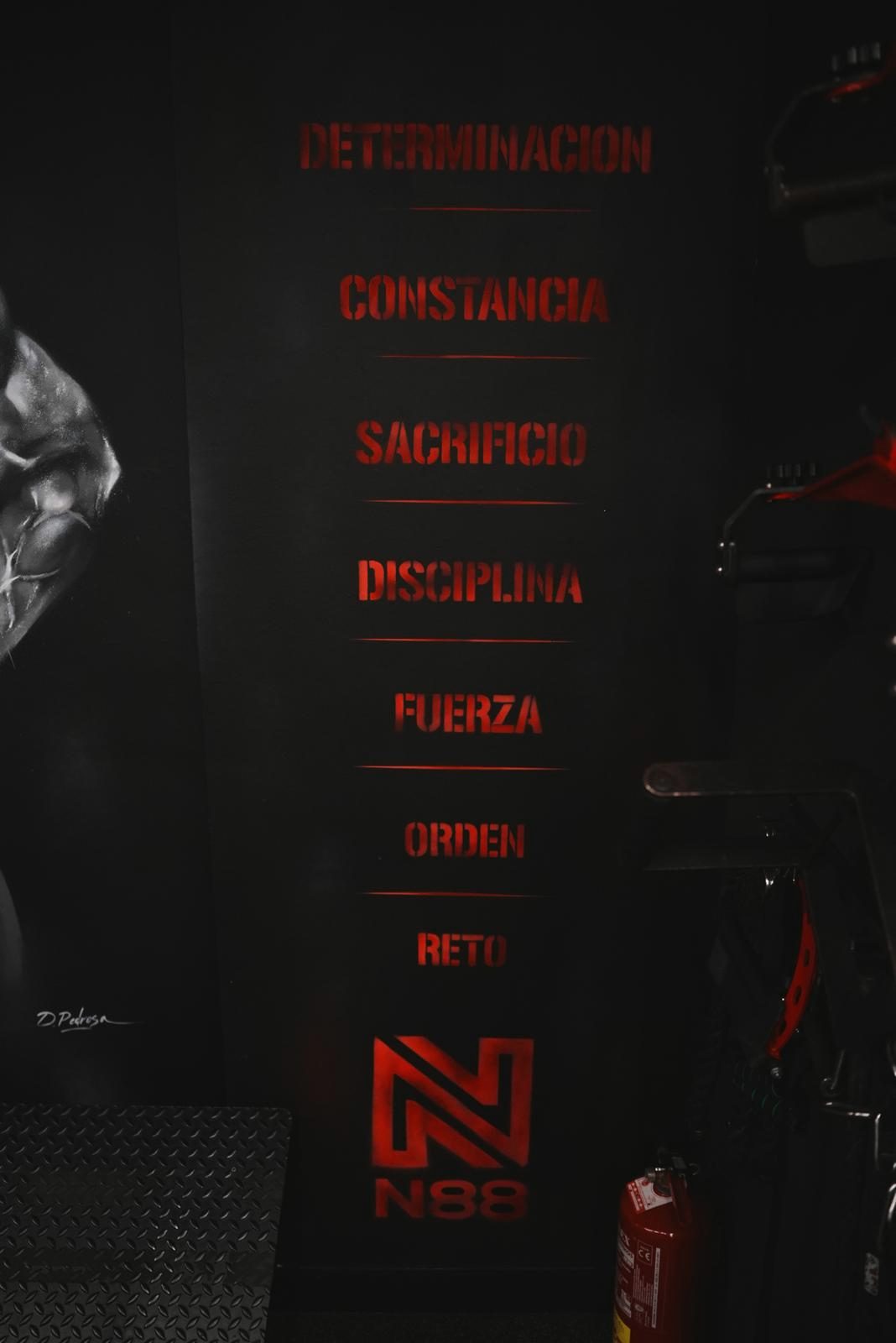 Muro de N88GYM con las palabras determinación, constancia, sacrificio, disciplina, fuerza, orden y reto
